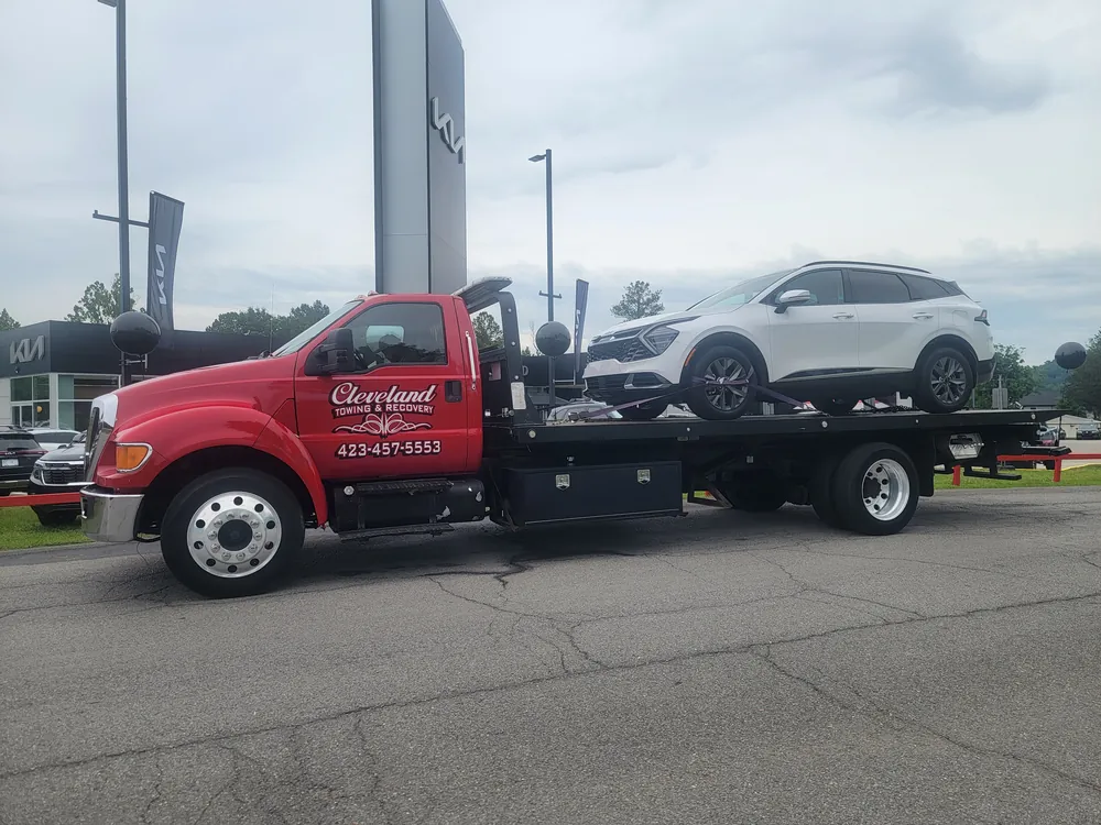A compact SUV strapped down on our rollback deck