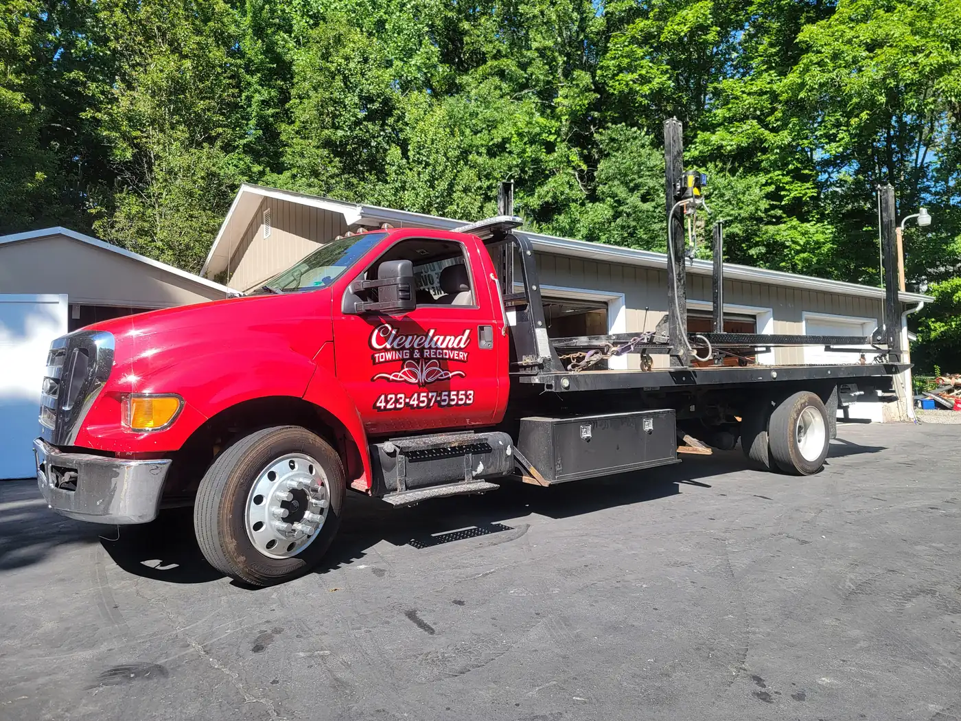 A two-post vehicle lift loaded on the rollback for relocation